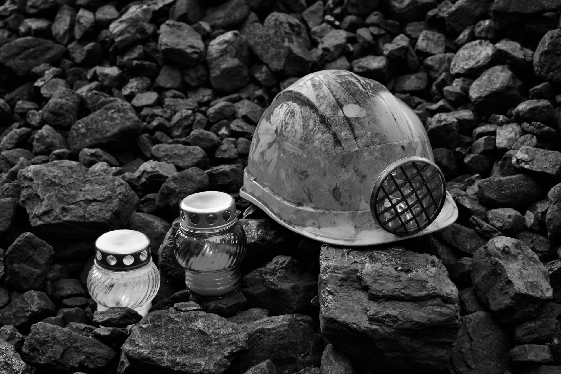 Vigil light, candle with mining helmet on cheap of coal after the fatal accident in the mine